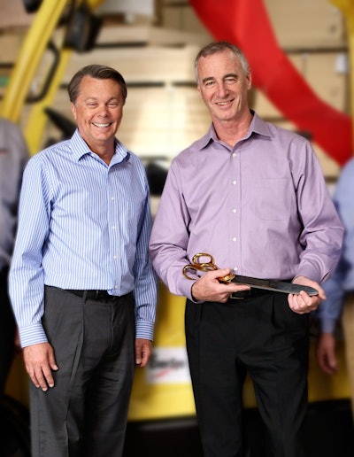 (L) Jeff Long, vice president, sales and service, EnerSys and (R) John Blakeney, chief financial officer, Atlantic Plywood cut the ribbon on the 5,000th lift truck converted to electric.