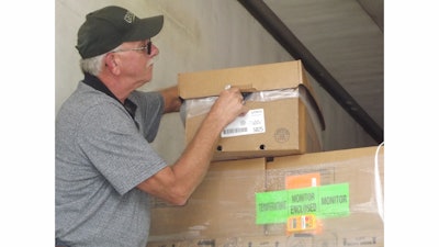 A George’s employee takes the temperature of a refrigerated chicken package in transit.
