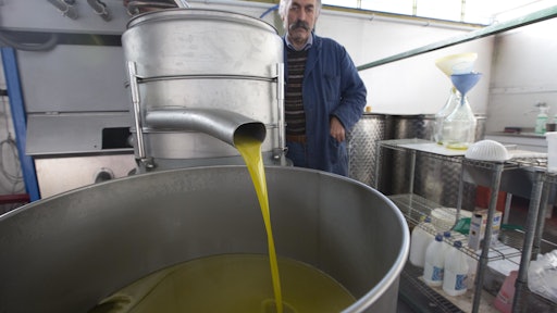In this Thursday, Nov. 13, 2014 photo, Augusto Spagnoli, oil producer, shows how his oil mill works, during an interview with The Associated Press, in Nerola, 50 kilometers (31 miles) from Rome. Italy’s 2014 olive harvest was declared by both producers and experts as the worst in history, due to adverse climatic conditions which helped the olive fly proliferate thus destroying the olives before they could be harvested. (AP Photo/Alessandra Tarantino)