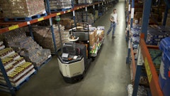 A warehouse worker uses Crown's QuickPick Remote to move the lift truck ahead in the aisle, eliminating the need to step up and down off the truck to move to the next pick position.