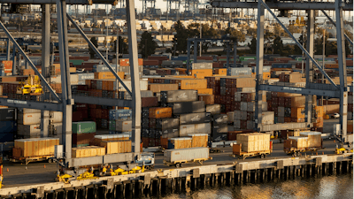 In this Wednesday, Jan. 14, 2015 file photo, shipping containers are stacked up waiting for truck transport at the Port of Los Angeles.