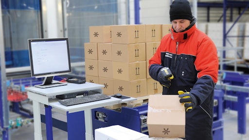 A worker in a cold storage facility uses the Viastore WMS via radio frequency for paperless picking.