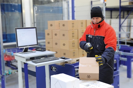 A worker in a cold storage facility uses the Viastore WMS via radio frequency for paperless picking.