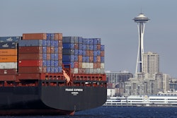 FILE - In this Feb. 15, 2015 file photo, the Space Needle towers in the background beyond a container ship anchored in Elliott Bay near downtown Seattle.