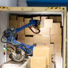 A Wynright robotic truck unloader palletizes in a warehouse.