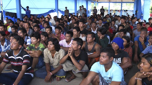 In this April 20, 2015, photo, former fishing slaves who were rescued from Indonesia’s remote island village of Benjina gather at a temporary government-run shelter on the island of Tual, Indonesia. Hundreds of men remain unaccounted for and are believed to be fishing in Papua New Guinea.