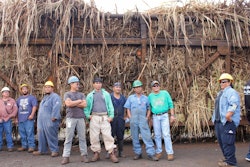 Some of the remaining workers at the mill stand in front of the last hauler truck of Hawaiian sugar cane.