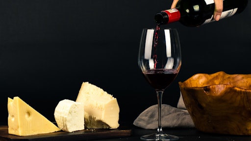 Photo Of Person Pouring Wine Into Glass Besides Some Cheese 1545529