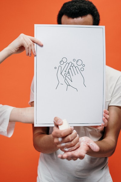 Person Holding A Poster On Proper Hand Washing 3952223