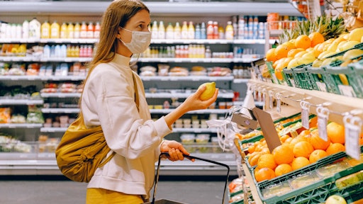 Woman In Yellow Tshirt And Beige Jacket Holding A Fruit 3962285