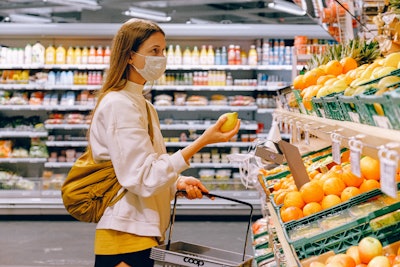 Woman In Yellow Tshirt And Beige Jacket Holding A Fruit 3962285