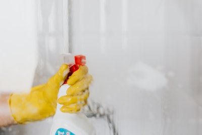 Person In Glove Spraying Detergent At Walk In Shower Glass 4239101