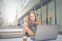 Woman In Brown Coat Holding A Bank Card 3784391