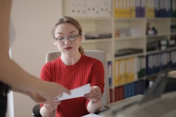 Young Woman Examining Document In Office 3770194