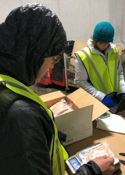 Lindy Miller and a team member perform a quality assurance audit, checking salmon in a freezer, at a distribution center in Florida.
