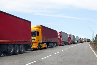 Trucks await entry at border crossing.