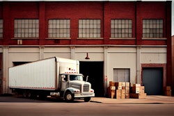 A loaded truck waits at a warehouse.