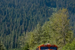 BNSF No. 6674 leads a double-stacked intermodal container train through mountains in the Scenic Subdivision in Washington state. Each double-stack intermodal train can take 280 trucks off the highways, resulting in lower emissions and fuel consumption. A BNSF train can haul one ton of freight 500 miles on one gallon of diesel fuel.
