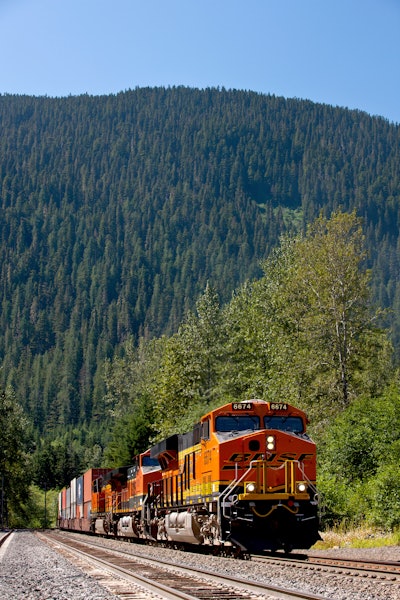 BNSF No. 6674 leads a double-stacked intermodal container train through mountains in the Scenic Subdivision in Washington state. Each double-stack intermodal train can take 280 trucks off the highways, resulting in lower emissions and fuel consumption. A BNSF train can haul one ton of freight 500 miles on one gallon of diesel fuel.