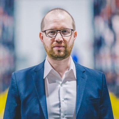 Professional man in blue blazer and glasses with blurred office background Headshot