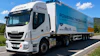 White IVECO refrigerated truck branded with NIVALIS cold chain logistics company branding, parked on a rural road with green landscape and blue sky.