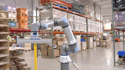 Collaborative robotic arm operating in an industrial warehouse with shelving and inventory.