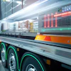 Futuristic food truck with digital display and green neon accents in modern warehouse