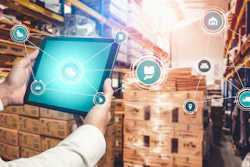 Warehouse worker holding tablet with digital logistics and supply chain management icons overlay