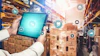 Warehouse worker holding tablet with digital logistics and supply chain management icons overlay