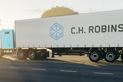 C.H. Robinson refrigerated truck traveling on highway at sunset with trees in background