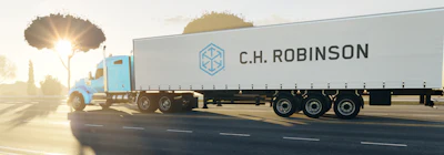 C.H. Robinson refrigerated truck traveling on highway at sunset with trees in background