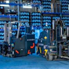 GIDEON branded forklifts displayed in a modern blue-lit warehouse with stacked plastic crates