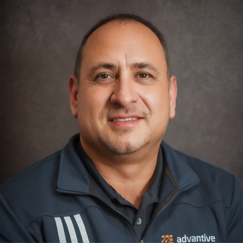 Professional headshot of man in navy Advantive branded jacket against gray background