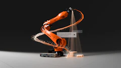KUKA industrial robotic arm performing dynamic welding motion with sparks and light effects against dark background