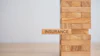 Wooden block tower with 'Insurance' text block representing financial stability and risk management