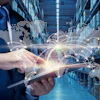 Businessman using tablet with digital world map and logistics network overlay in warehouse