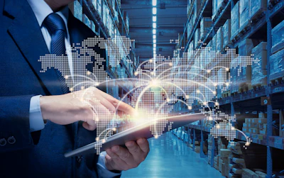 Businessman using tablet with digital world map and logistics network overlay in warehouse