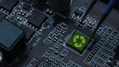 Green recycling symbol on computer circuit board with electronic components